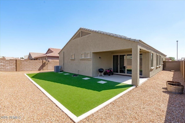 rear view of property featuring a patio, central AC unit, a fenced backyard, and stucco siding