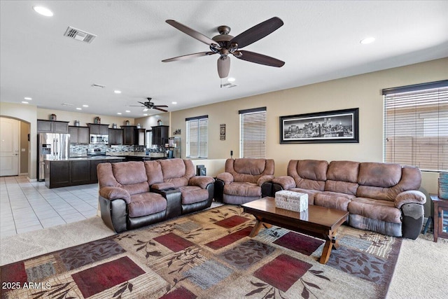 living room with arched walkways, visible vents, recessed lighting, and light tile patterned floors