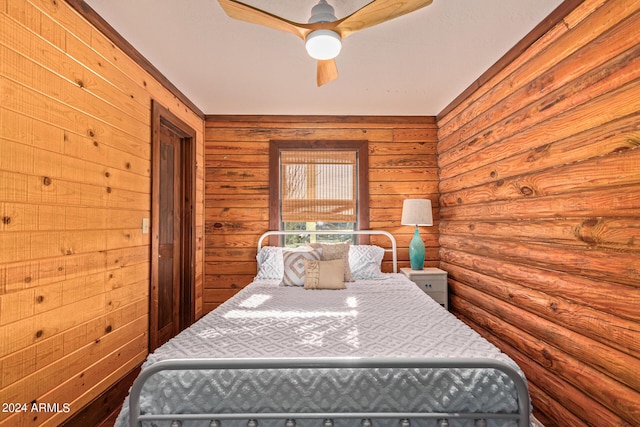 bedroom featuring ceiling fan and wood walls