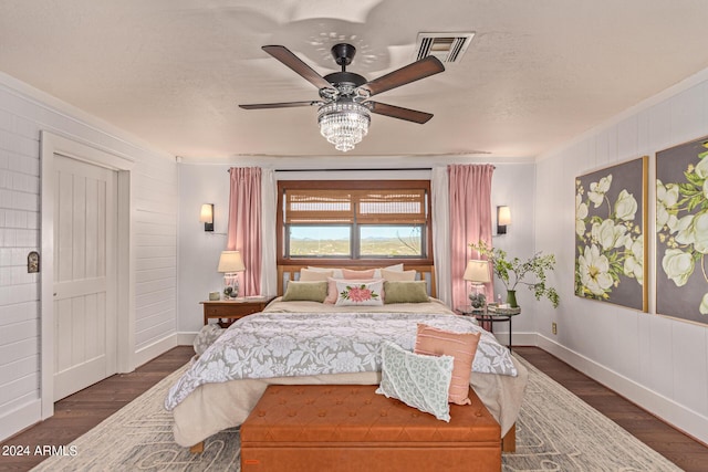 bedroom with ornamental molding, ceiling fan, and dark wood-type flooring