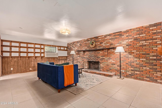 unfurnished living room with light tile patterned flooring, a brick fireplace, wood walls, and brick wall