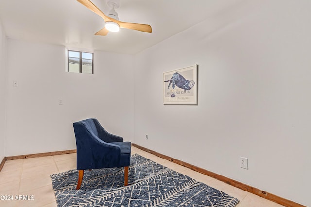 living area with ceiling fan and tile patterned flooring