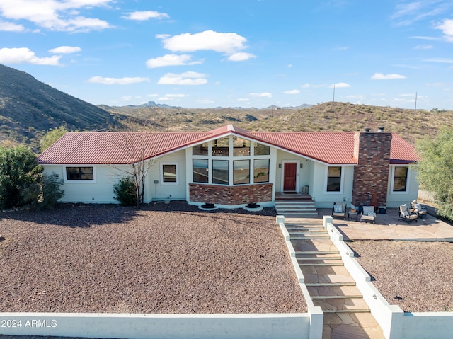 view of front of home featuring a mountain view and a patio