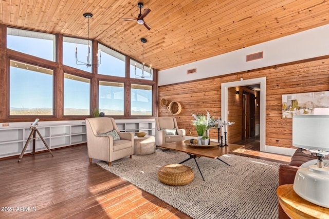 living room with wooden ceiling, high vaulted ceiling, ceiling fan with notable chandelier, wooden walls, and hardwood / wood-style flooring