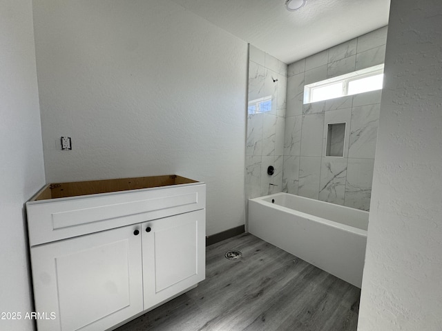 bathroom featuring hardwood / wood-style floors and tiled shower / bath combo