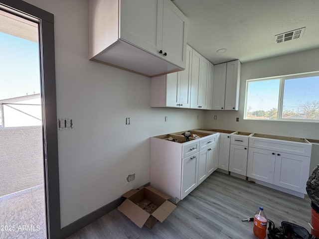 kitchen with white cabinets and light hardwood / wood-style flooring