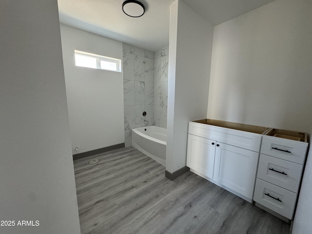 bathroom featuring hardwood / wood-style floors, tiled shower / bath, and vanity