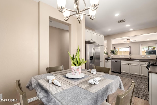 152 N 194th Ln, Buckeye, AZ 85326 - dining room featuring ceiling fan with notable chandelier, light wood finished floors, visible vents, and recessed lighting