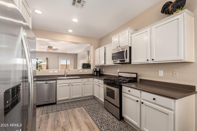 152 N 194th Ln, Buckeye, AZ 85326 - kitchen with dark countertops, a sink, visible vents, and stainless steel appliances