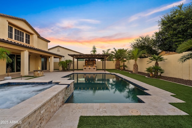 10331 E Starion Ave, Mesa, AZ 85212 - pool at dusk featuring a fenced backyard, a patio, a ceiling fan, an outdoor kitchen, and a pool with connected hot tub
