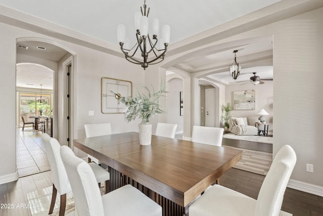 10331 E Starion Ave, Mesa, AZ 85212 - dining area featuring arched walkways, a chandelier, a ceiling fan, and wood finished floors