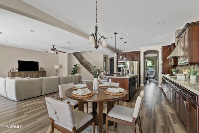 10331 E Starion Ave, Mesa, AZ 85212 - dining area with arched walkways, a ceiling fan, recessed lighting, wood finished floors, and stairway