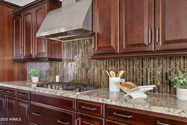 10331 E Starion Ave, Mesa, AZ 85212 - kitchen featuring wall chimney range hood, stainless steel gas stovetop, tasteful backsplash, and light stone counters