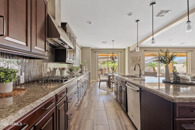 10331 E Starion Ave, Mesa, AZ 85212 - kitchen with stainless steel appliances, wall chimney range hood, decorative backsplash, light stone counters, and dark brown cabinets