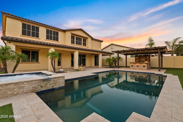 10331 E Starion Ave, Mesa, AZ 85212 - back of house at dusk with exterior kitchen, a patio, a tiled roof, and stucco siding
