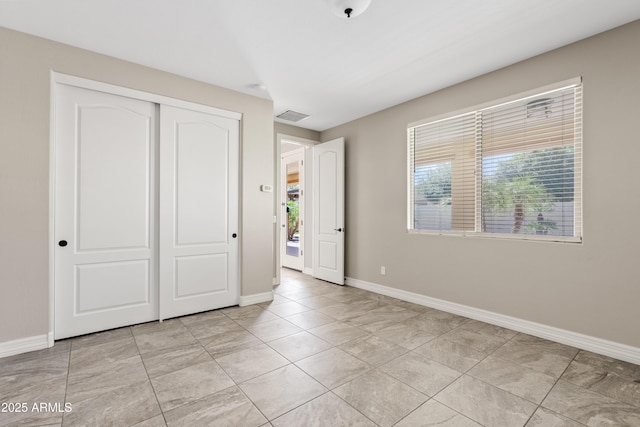 10331 E Starion Ave, Mesa, AZ 85212 - unfurnished bedroom featuring multiple windows, light tile patterned floors, and a closet