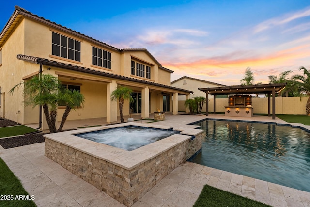 10331 E Starion Ave, Mesa, AZ 85212 - rear view of house with stucco siding, a patio, an outdoor kitchen, and a pool with connected hot tub