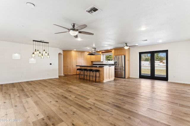 unfurnished living room featuring french doors, ceiling fan, sink, and light hardwood / wood-style floors