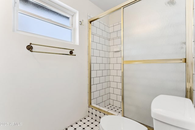 bathroom with toilet and a shower with shower door