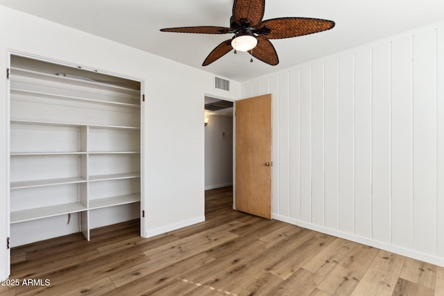 unfurnished bedroom featuring hardwood / wood-style floors, a closet, and ceiling fan