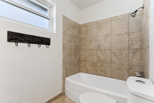 bathroom featuring toilet, tiled shower / bath combo, and tile patterned flooring