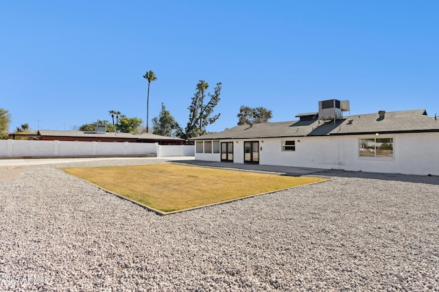 back of property with a yard and a patio area