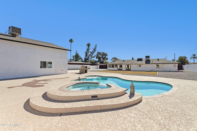 view of swimming pool featuring an in ground hot tub and a patio area