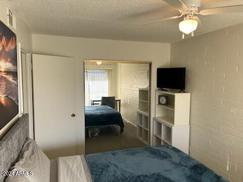 bedroom with a textured ceiling and ceiling fan