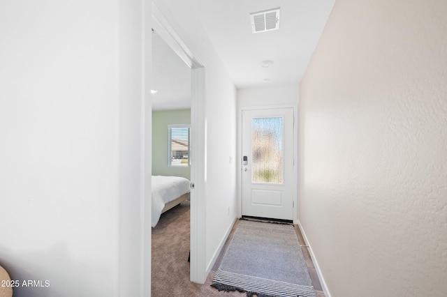 doorway with light colored carpet