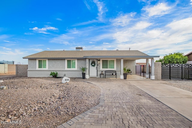 single story home featuring a carport, driveway, stucco siding, and fence