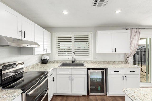 kitchen featuring wine cooler, a sink, stainless steel electric range, under cabinet range hood, and visible vents