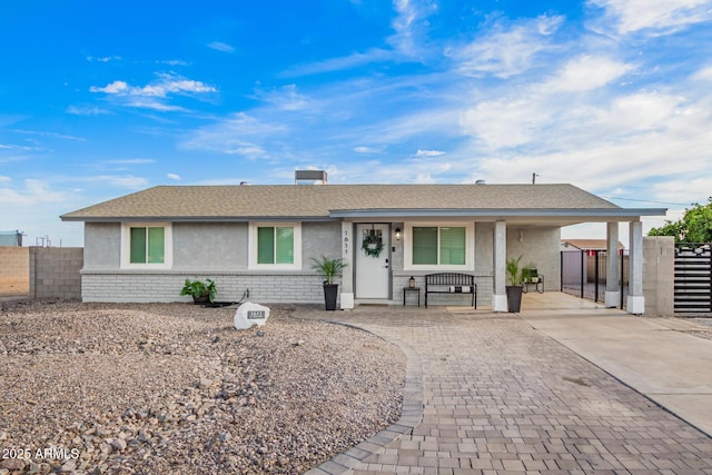 ranch-style home with a carport, driveway, stucco siding, and fence