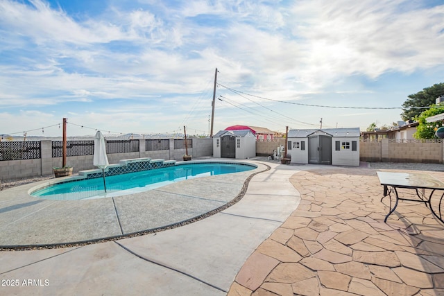 view of pool with a patio, a fenced in pool, a fenced backyard, an outbuilding, and a shed