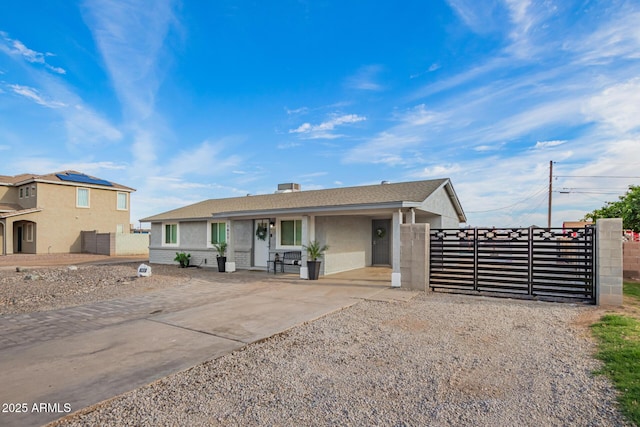 ranch-style home featuring a gate, concrete driveway, stucco siding, and fence