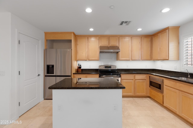 kitchen featuring sink, appliances with stainless steel finishes, a kitchen island, dark stone counters, and light brown cabinets