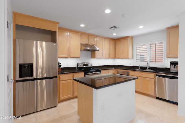 kitchen featuring light brown cabinetry, sink, stainless steel appliances, and a kitchen island