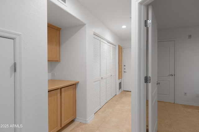 hall with light tile patterned floors