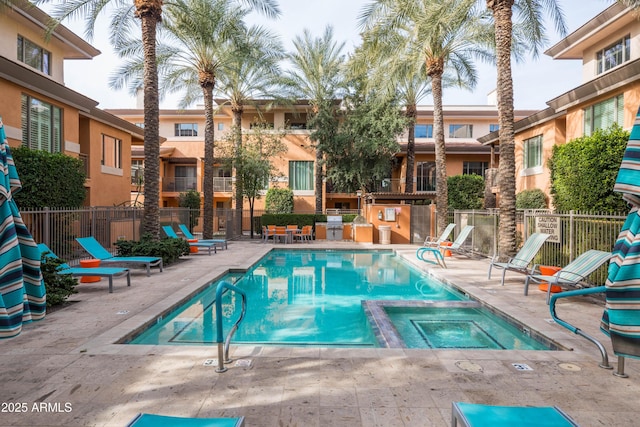 view of swimming pool featuring a community hot tub and a patio area