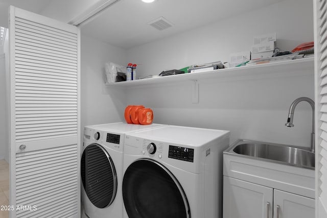 laundry area featuring cabinets, sink, and independent washer and dryer