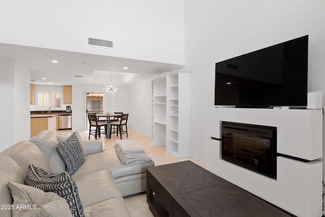 living room featuring sink and a notable chandelier