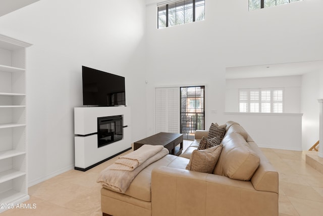 tiled living room featuring built in shelves and a high ceiling