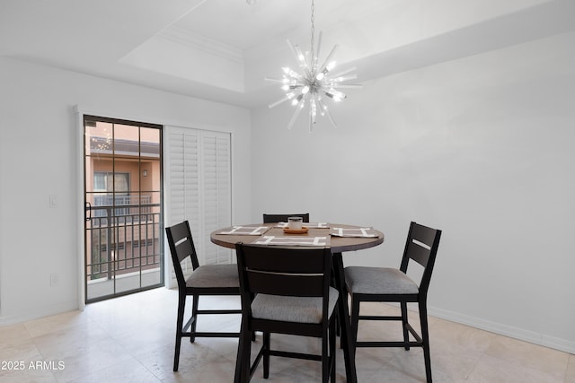 dining area featuring crown molding, a tray ceiling, and a notable chandelier