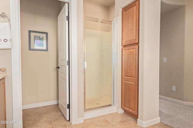 bathroom featuring a shower with door, tile flooring, and vanity