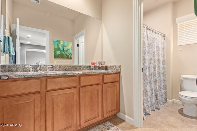 bathroom featuring tile flooring, vanity, and toilet