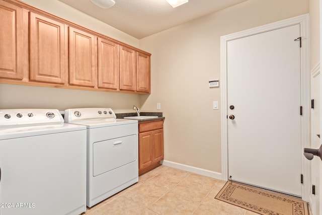 washroom featuring sink, washer and clothes dryer, cabinets, and light tile floors