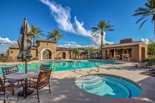 view of swimming pool with a patio area and a hot tub