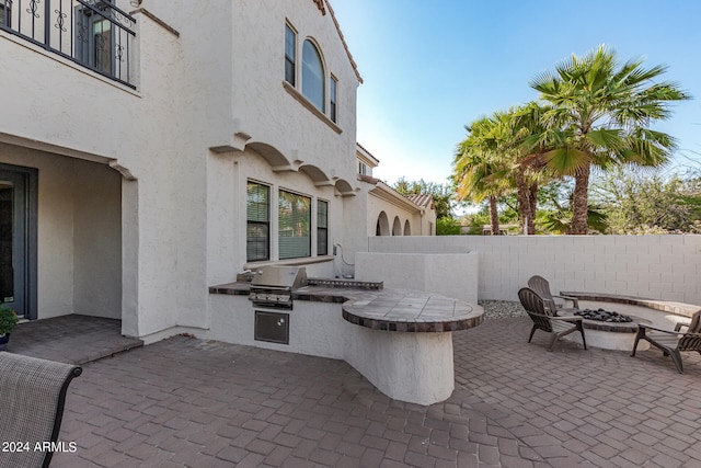 view of patio / terrace with an outdoor kitchen, an outdoor fire pit, and area for grilling