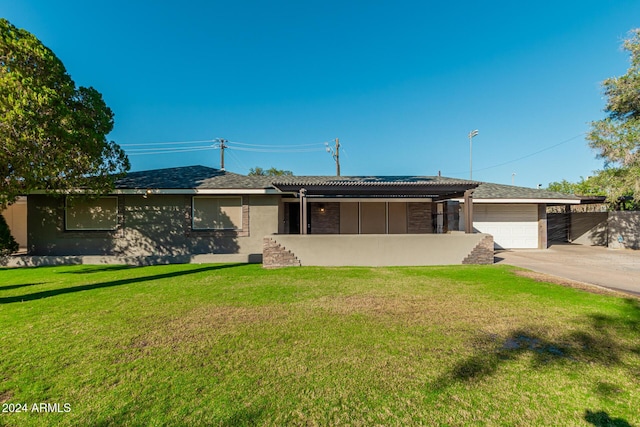 view of front of property featuring stucco siding, driveway, a front lawn, and a garage