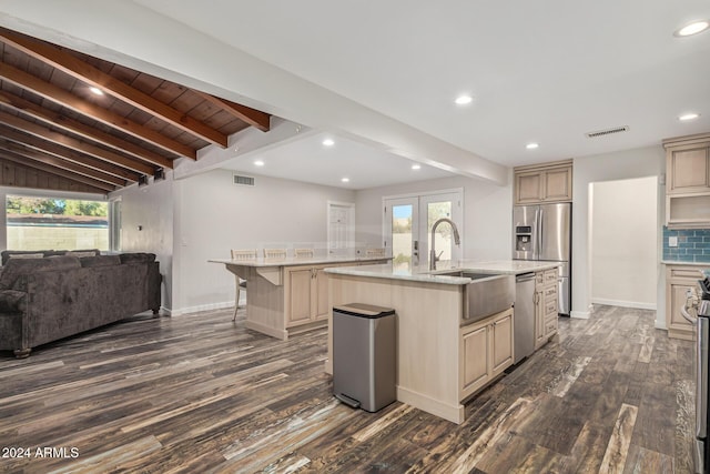 kitchen with visible vents, open floor plan, an island with sink, appliances with stainless steel finishes, and a sink