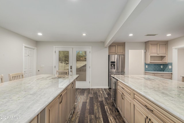 kitchen featuring dark wood finished floors, stainless steel fridge with ice dispenser, visible vents, and light stone countertops